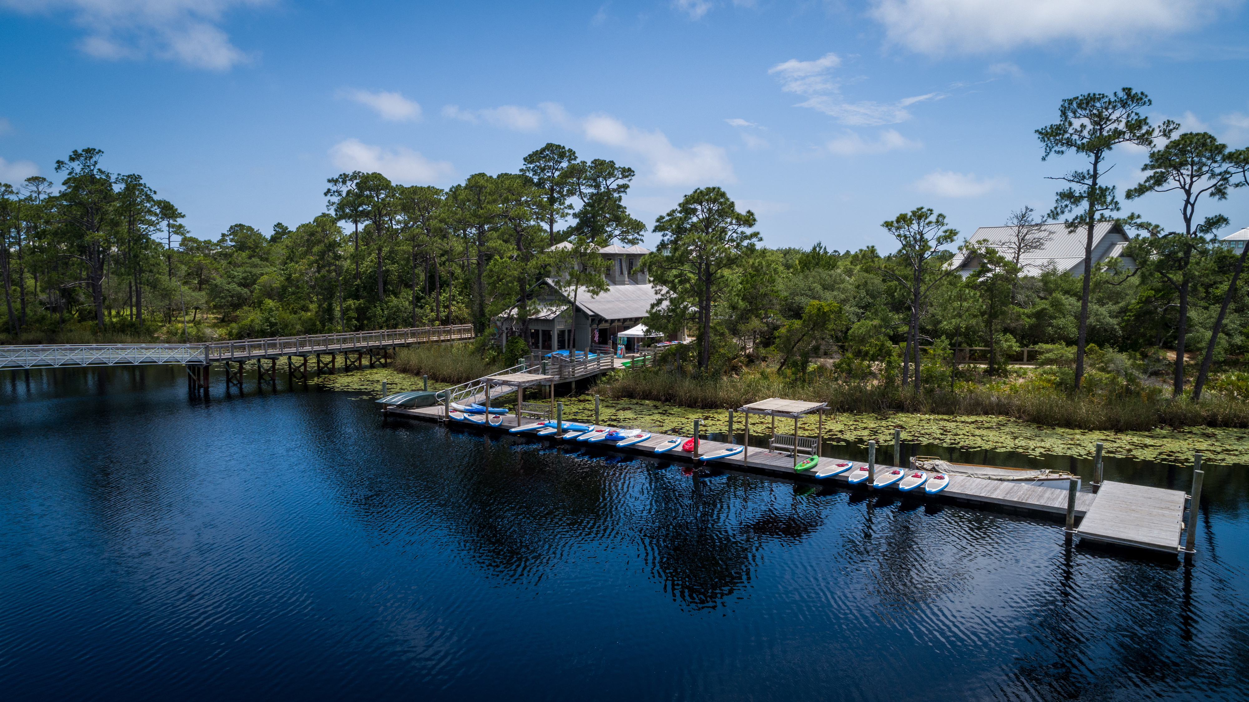 A view of the Watercolor boat house with kayaks and canoes lined up out front on the lake 